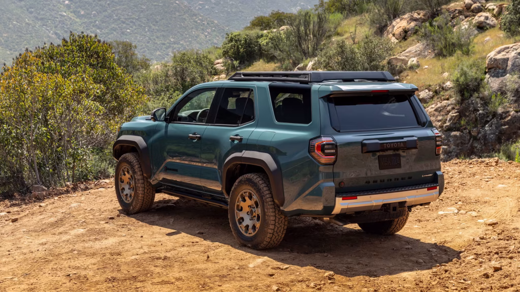 An angled shot of the 2025 Toyota 4Runner on a rocky terrain background, emphasizing its rugged appeal and redesigned front grille.